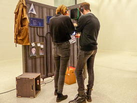 Eine junge Frau und ein junger Mann sind von hinten zu sehen und spielen das Escape Game BioEconomyNow im Futurium in Berlin. Foto: Wissenschaft im Dialog | Sina Metz